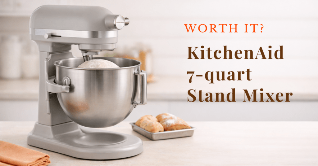 a bowl-lift stand mixer with dough in the bowl and a small tray of bread beside it in a bright kitchen